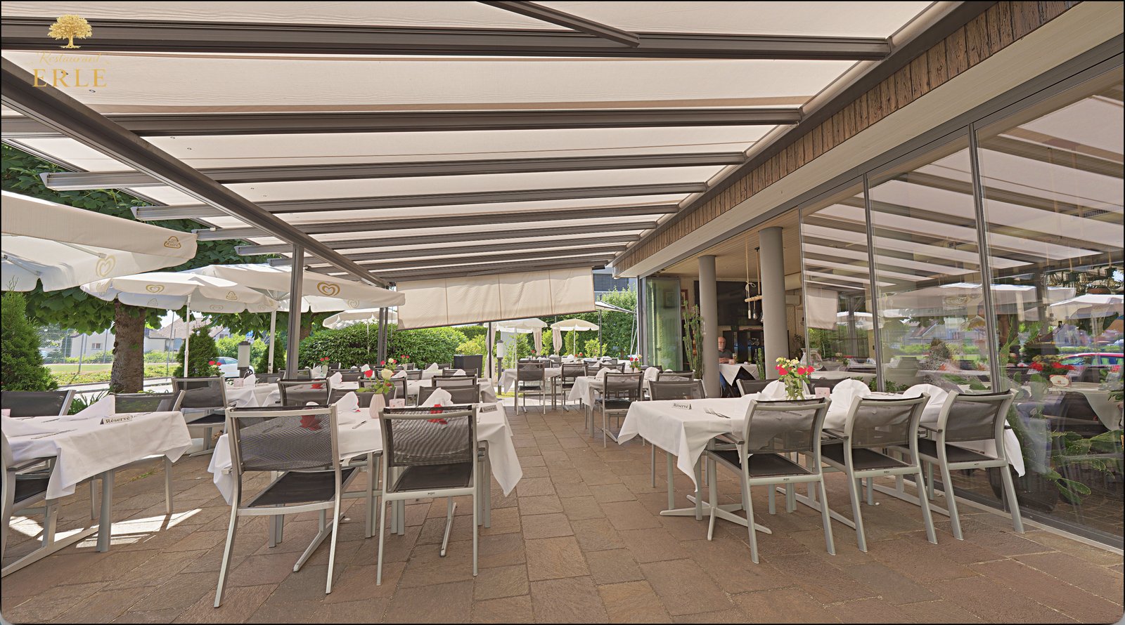 Restaurant Erle Gartenwirtschaft mit gedeckten Tischen und Sonnenschirmen