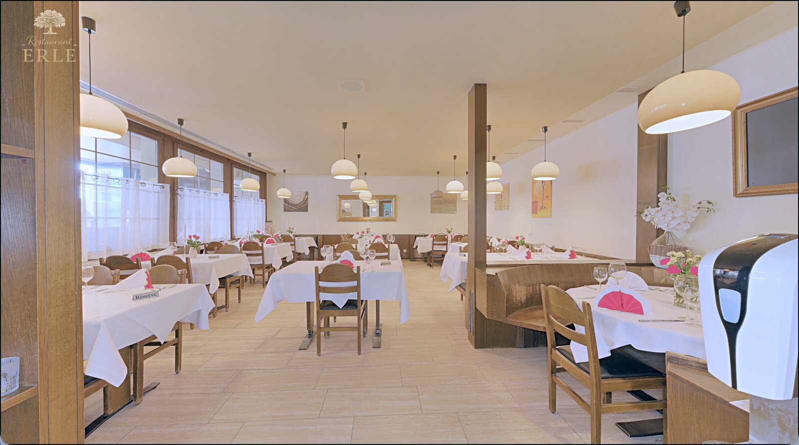 Gemütlicher Gastraum im Restaurant Erle mit gedeckten Tischen und warmer Beleuchtung